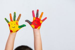 Les mains d'un enfant de l'ADSEA 02 couvertes de peinture